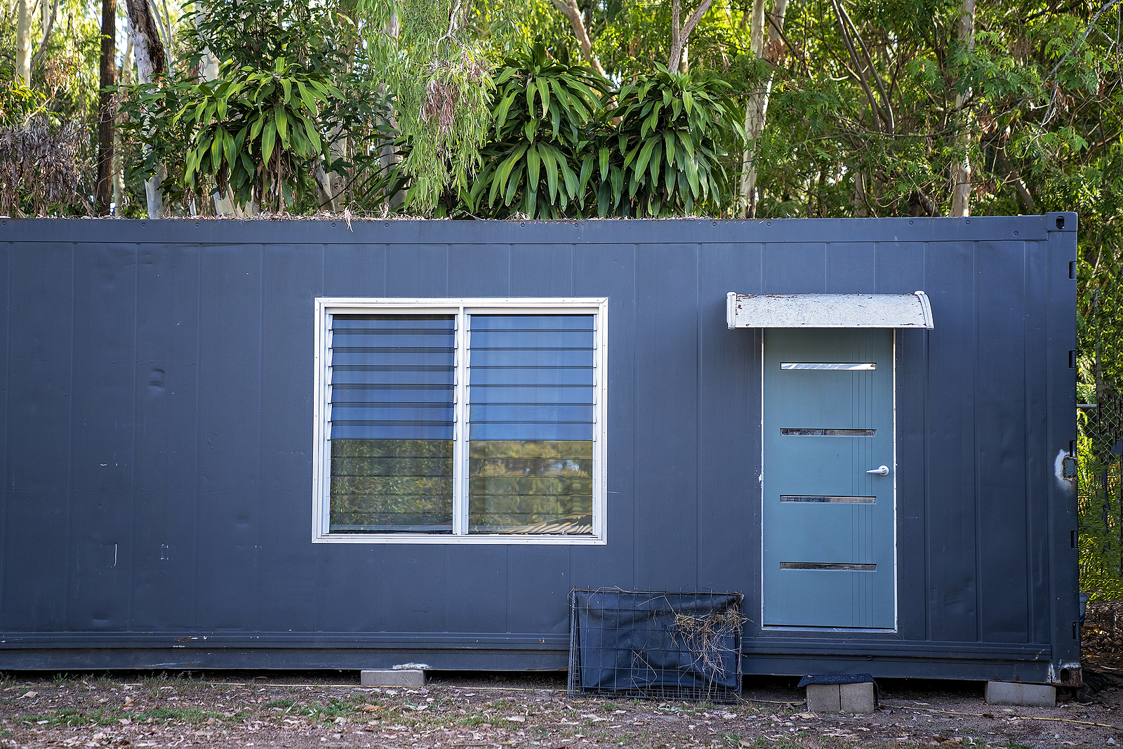 An Old Metal Container Converted Into A Building In A Home Garde